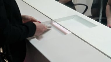 Çalışan ve müşteri döviz bürosundaki bir tezgahta para sayıyorlar. Nakit bölümünün vitrininde parası olan bir kadın.. 