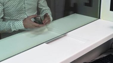 Çalışan ve müşteri döviz bürosundaki bir tezgahta para sayıyorlar. Nakit bölümünün vitrininde parası olan kadın ve erkek.. 
