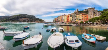 Porto Venere, İtalya - 7 Nisan 2019: San Lorenzo kilisesi ve Liguria, İtalya 'daki Doria Kalesi ile Portovenere' nin renkli renkli limanı.