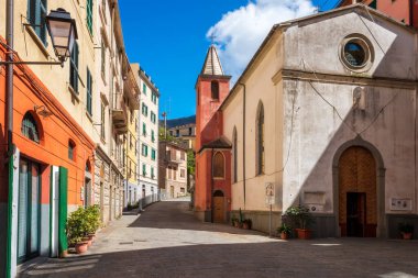 İtalya, Liguria bölgesindeki Cinque Terre Ulusal Parkı 'nın beş ünlü renkli köyünden biri olan Riomaggiore' daki renkli binalarla dolu dar bir caddenin güzel manzarası..