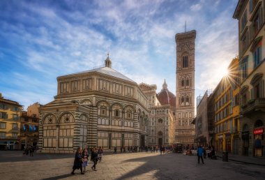 Floransa, İtalya - 7 Nisan 2019: Turistler sabah güneşiyle aydınlanan ünlü Piazza del Duomo ve Katedral Santa Maria del Fiore 'dan geçtiler