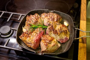 Izgara tavada baharatlı çiğ dana bifteğinin yakın plan görüntüsü.