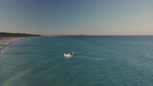 在美丽的无边无际的沙滩上盘旋 在碧绿的大海中划船 — 图库视频影像