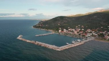 Yunanistan 'ın Thasos adasının kayalık kıyı şeridinde gün batımında küçük bir marina limanına demir atmış.