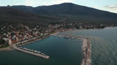 Yunanistan 'ın Thasos adasının kayalık kıyı şeridinde gün batımında küçük bir marina limanına demir atmış.