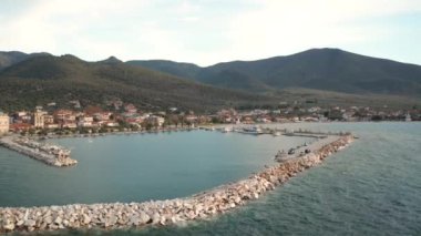 Yunanistan 'ın Thasos adasının kayalık kıyı şeridinde gün batımında küçük bir marina limanına demir atmış.