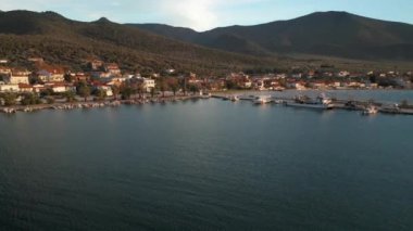 Yunanistan 'ın Thasos adasının kayalık kıyı şeridinde gün batımında küçük bir marina limanına demir atmış.
