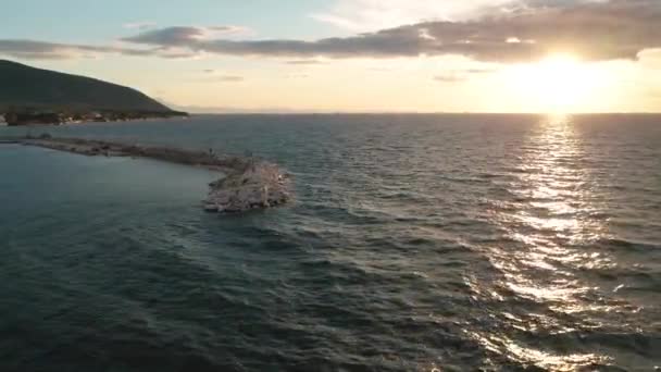 Vidéo ariale d'une petite marina de village avec des bateaux ancrés sur la côte rocheuse de l'île de Thasos en Grèce au coucher du soleil 
