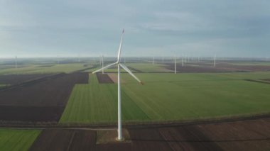 Bahar tarlaları boyunca rüzgar türbinlerinin etrafında uçan hava. Temiz ve Yenilenebilir Rüzgâr Güç Çiftliği hareket halinde. Yeşil enerji, sürdürülebilir alternatif elektrik, kirlilik ortamı yok.