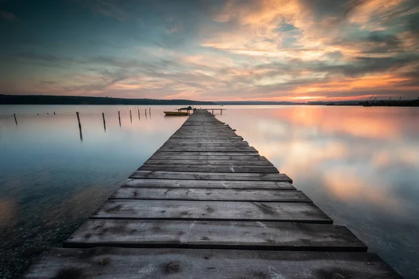 ボートと木製の桟橋と壮大な長い露出湖の夕日 — ストック写真