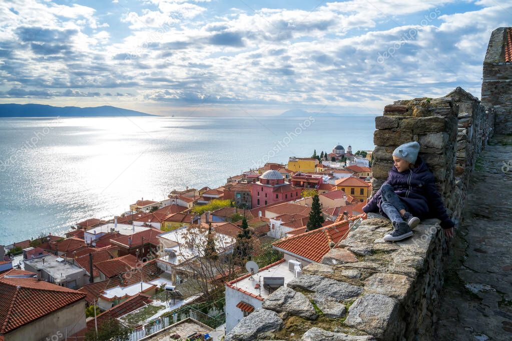 Little girl enjoys the view from the fortress of the old city of Kavala to the Aegean islands, northern Greece