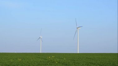 Bahar tarlaları boyunca rüzgar türbinlerinin etrafında uçan hava. Temiz ve Yenilenebilir Rüzgâr Güç Çiftliği hareket halinde. Yeşil enerji, sürdürülebilir alternatif elektrik, kirlilik ortamı yok.