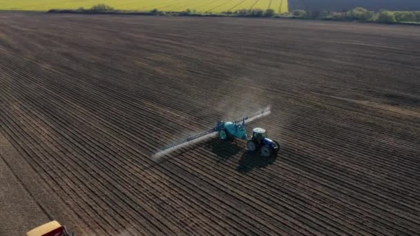 特殊な設置により播種場を灌漑するトラクターの空中ビュー — ストック動画