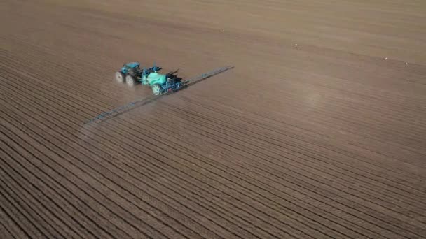 通过特殊装置灌溉播种地的拖拉机的空中视图 — 图库视频影像