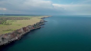 Yeşil alanlar ve ağaçlarla kaplı kayalık kayalık kıyı şeridinin panoramik videosu. Karadeniz kıyısında bahar zamanı, Yailata - Bulgaristan 'ın ulusal arkeoloji ve doğa rezervi.