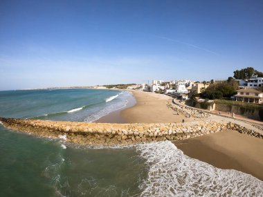 Ufuk çizgisine bakan hava kaydı, dalgaların dalgalanması Akdeniz 'e karşı, yeşil ve berrak su, açık mavi gökyüzü, Santa Maria, Cadiz, Endülüs limanında alçak gelgit.