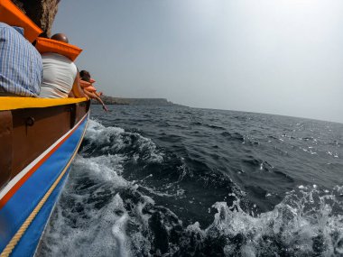 Yöre sakinleri ve turistler, can yelekleriyle korunan bir turizm teknesiyle Malta kıyılarını ziyaret ediyorlar. Tema parkı.