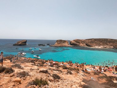 Bölge sakinleri ve turistler Comino Beach, Malta 'nın tadını çıkarıyorlar. Malta 'nın en çok ziyaret edilen plajlarından biri, çoğu insanın havayı, plajları ve eğlenceleri sevdiği bir yer..