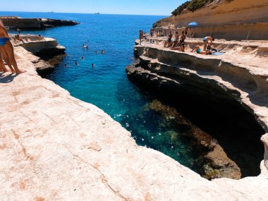 İnsanlar Malta 'nın doğal havuzunun keyfini çıkarıyor..