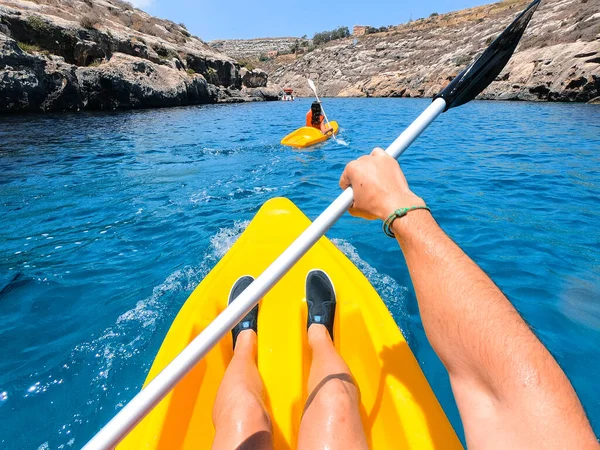 Turistler Malta 'nın Gozo adasındaki plajlardan birinde kano çalışması yapıyorlar. İnsanlar sahilde yazın tadını çıkarıyor..