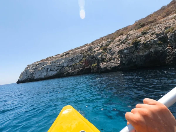 Turistler Malta 'nın Gozo adasındaki plajlardan birinde kano çalışması yapıyorlar. İnsanlar sahilde yazın tadını çıkarıyor..