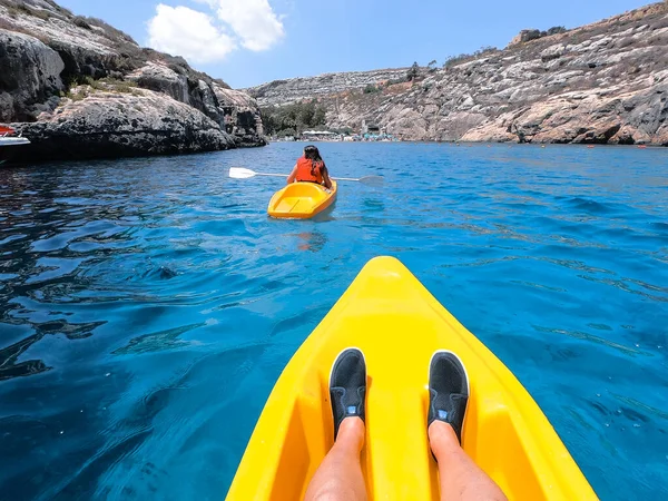 Turistler Malta 'nın Gozo adasındaki plajlardan birinde kano çalışması yapıyorlar. İnsanlar sahilde yazın tadını çıkarıyor..