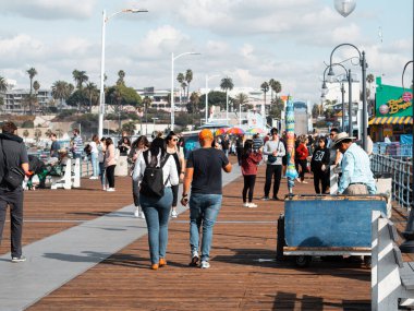 Santa Monica, ABD - 25 Kasım 2019: Rıhtımda turistlerin ve sakinlerin yürüdüğü ünlü Santa Monica İskelesi.