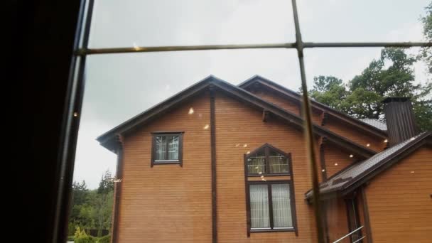 Window view of a wooden brown house in cloudy weather — Stock Footage Window view of a wooden brown house in cloudy weather Stock Footage