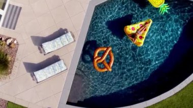 Genç kadın havuzu oyuncaklar, modern ev mavi yüzme havuzunda bronzlaşma