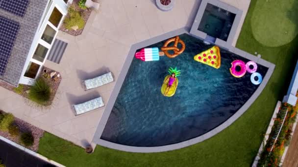 Young woman resting on fun pool toys in blue swimming pool at modern house — Stock Footage Young Woman Resting Fun Pool Toys Blue Swimming Pool Modern Royalty Free Stock Footage