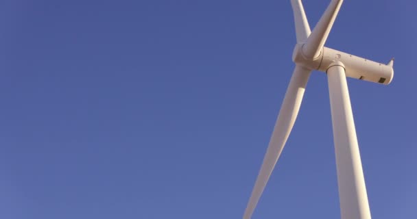 Turbina Eólica Bajo Ángulo Girando Contra Cielo Azul — Vídeo de stock