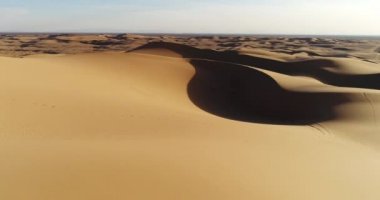 Çölde kum tepeleri üzerinde günbatımında uçan havadan görünümü