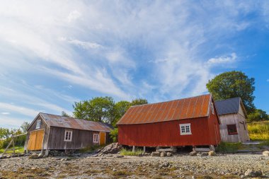 Plajdaki rorbu adlı tipik bir balıkçı evi denizi çevrelemektedir. Norveç.