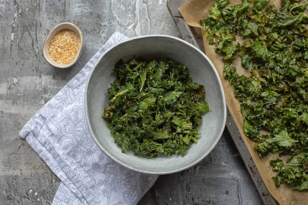 Homemade organic green kale chips with salt, sesame, chili and oil.