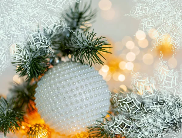 Вітальна листівка на Різдво та Новий рік. Красива куля, соснові гілки і гірлянда на снігу . Ліцензійні Стокові Фото