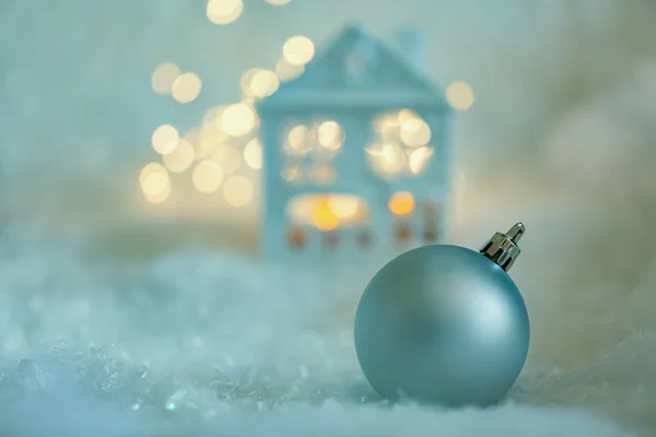 Carte de voeux Joyeux Noël. La maison bleue est couverte de neige, d'une boule, d'une guirlande et de branches vertes. Concentration douce Images De Stock Libres De Droits