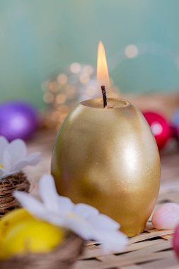 Paskalya kartı yanan altın mum. Ahşap bir masada mum ve yumurta kutlaması.. 