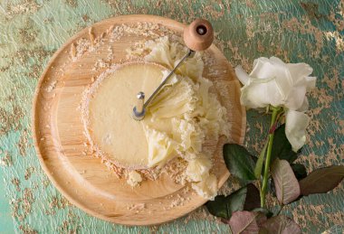 Fransız peyniri Keşiş kafası tahta yuvarlak bir yüzeyde dilimlenmiş..