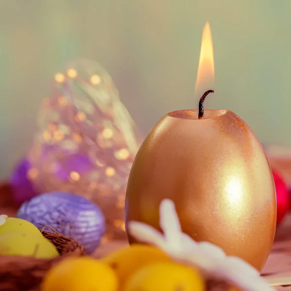 Carte de vœux Bougie dorée de Pâques et œufs en chocolat en feuille de couleur. Beau fond flou et bokeh lumineux . Images De Stock Libres De Droits