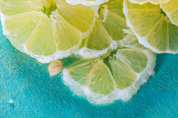 Top view of yellow lemon slices. Transparent juicy slices of lemon blue surface. Healthy vegetarian food.