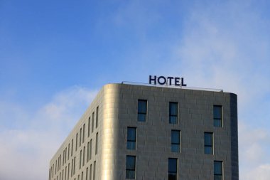 İtalya, Piedmont - kış 2019: Çelik kiremitli modern otel, İtalyan Alpleri manzaralı, 2006 'da kış olimpiyatları için inşa edilmiş. Olimpik ahşap meşalenin bir kopyasını görebilirsiniz.