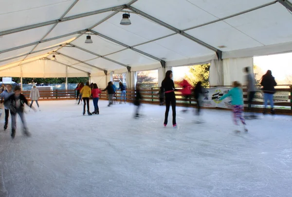 Un día sin preocupaciones en el parque de patinaje sobre hielo, invierno italiano bajo las montañas de los Alpes —  Fotos de Stock