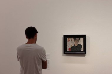 Wien, Avusturya - Ağustos 2019: Beyaz tişörtlü adam Leopold Müzesinde Egon Schiele 'in kendi portresine bakıyor.