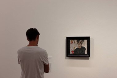Wien, Austria - aug 2019: Man with white tshirt looking at Egon Schiele self portrait at Leopold Museum. clipart