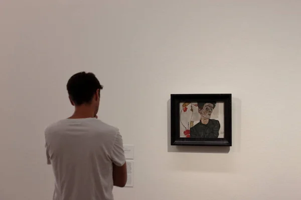 Wien, Austria - aug 2019: Man with white tshirt looking at Egon Schiele self portrait at Leopold Museum. — Stock Photo, Image