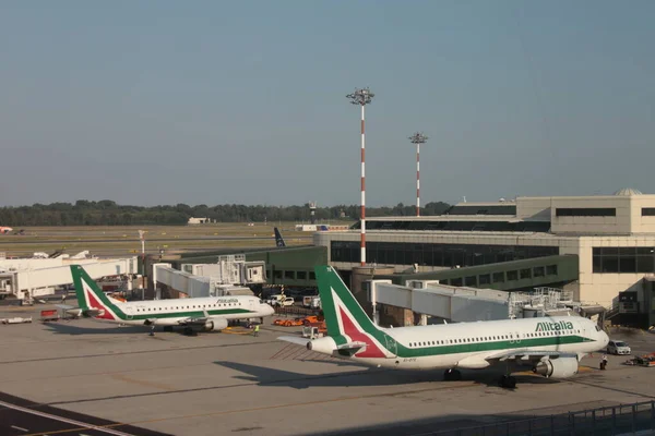 Milan, İtalya - Ağustos 2019: İki Alitalia uçağı Malpensa Uluslararası Havaalanına yanaştı.