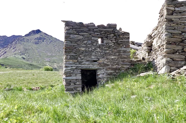 Foto cortada de uma antiga cabana de montanha com os Alpes italianos no fundo — Fotografia de Stock