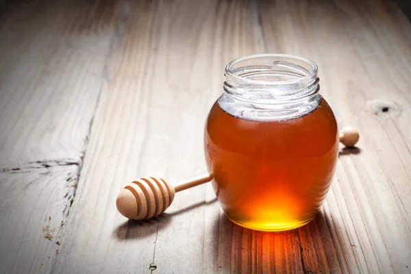 Tarro de vidrio lleno de miel — Foto de Stock