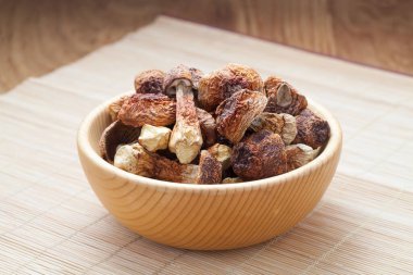 Kurutulmuş Agaricus blazei mantarı bambu arka planda ahşap bir kasede