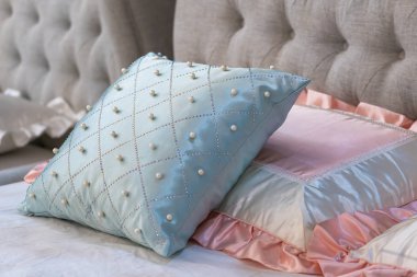 Kahverengi kumaş yastıklı, inci ve pembe kumaş yastıklı modern mavi iç dekorasyon.